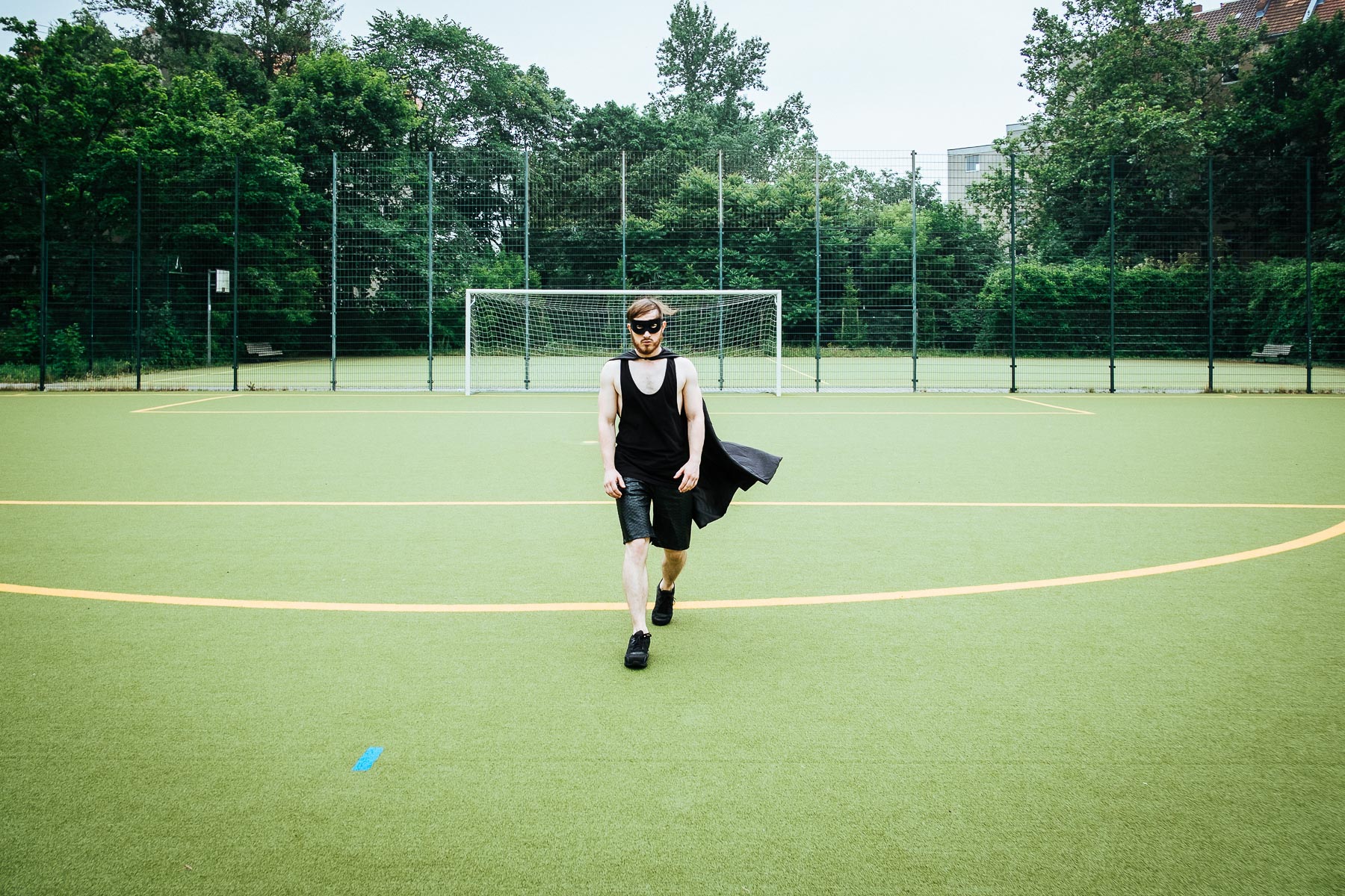 Portrait Jörg Albrecht als Batman auf einem Sportplatz in Berlin