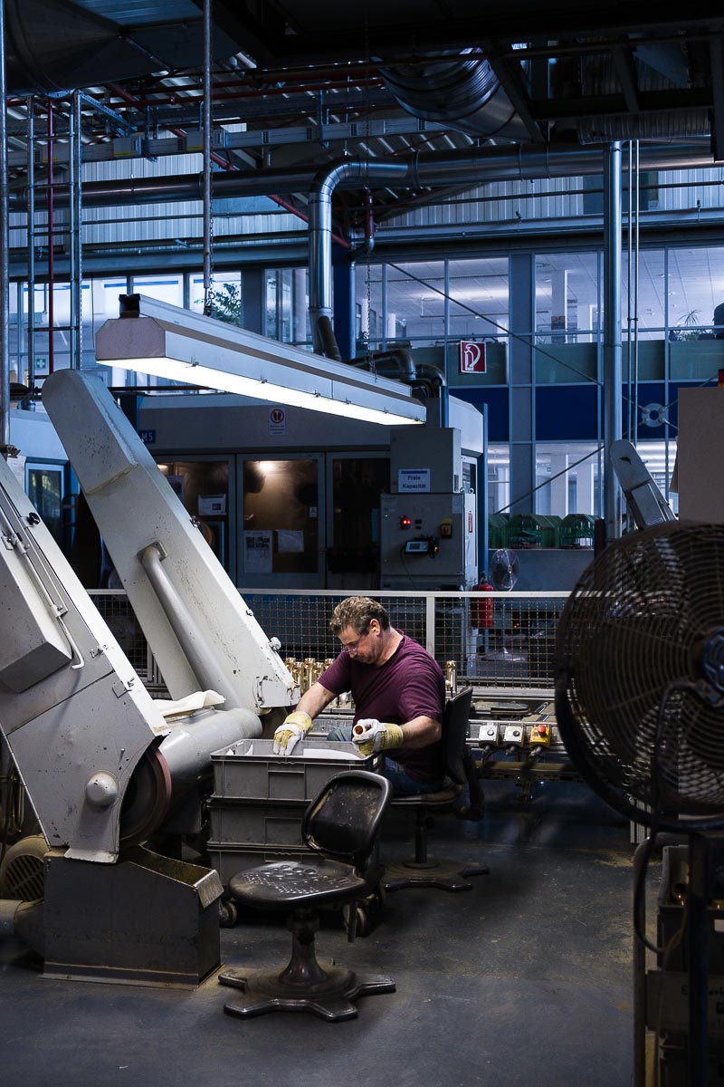 Mitarbeiter der Firma Grohe in der Produktion mit einer Schleifmaschine