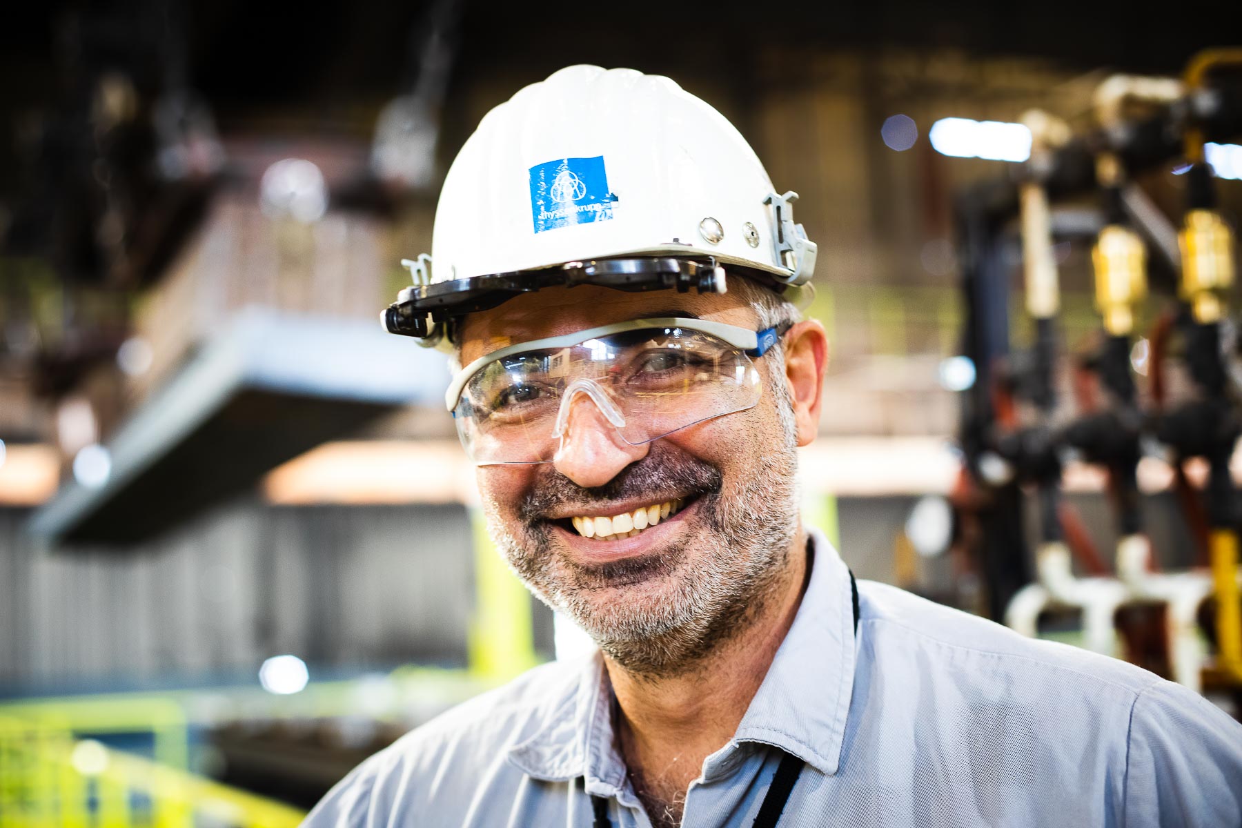 Portrait eines Mitarbeiters von ThyssenKrupp mit Helm