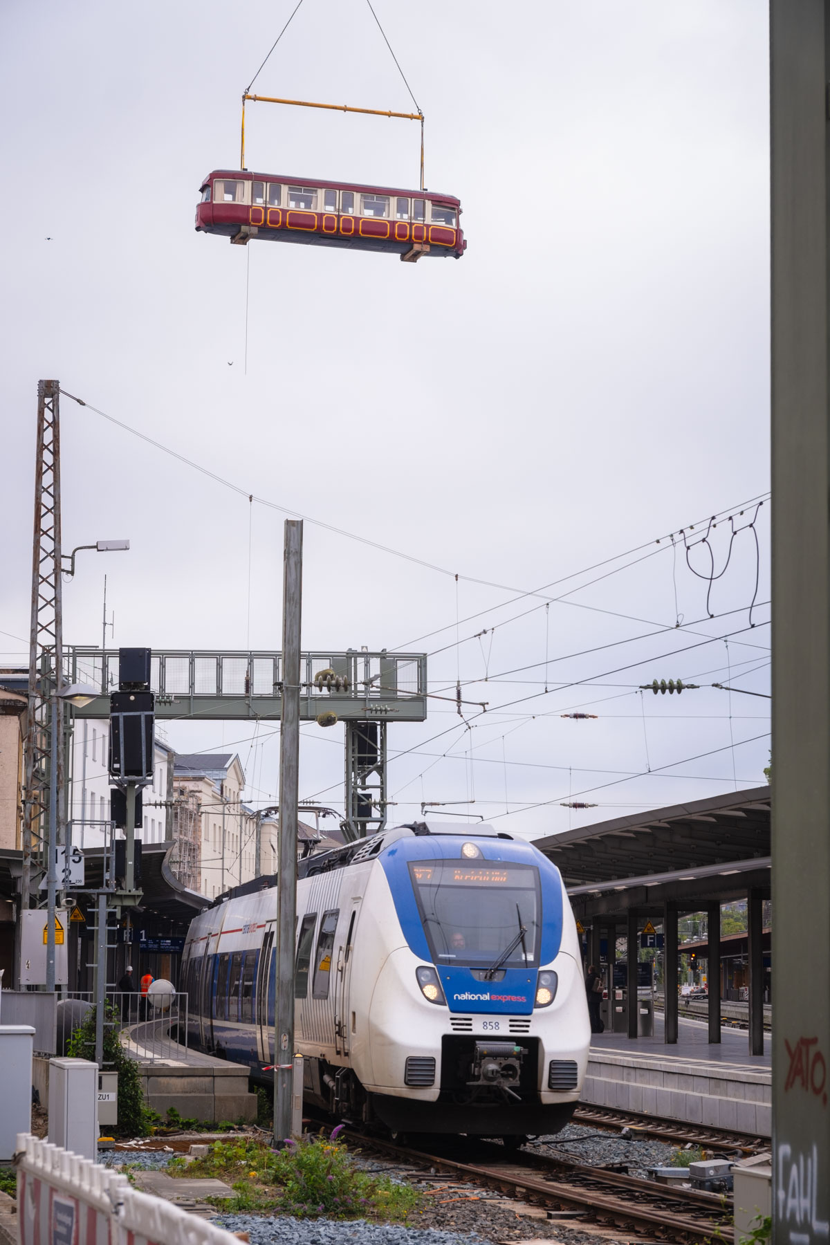 Ein alter Waggon der Schwebebahn wird mit einem Autokran über die Gleise des Wuppertaler Hauptbahnhofs in ein Zwischengebäude des Bahnhofs gehoben