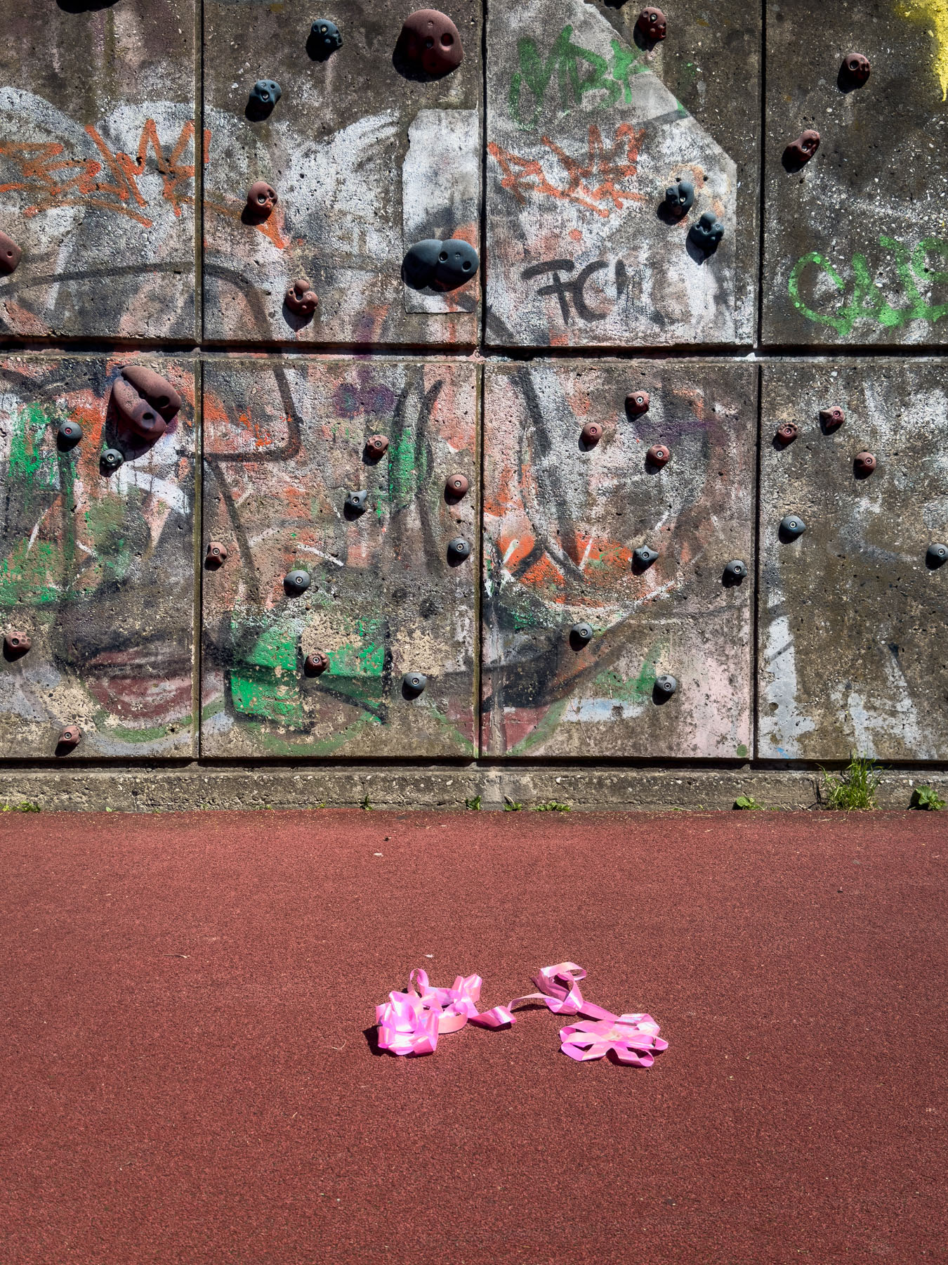 Eine pinke Schleife vor einer Kletterwand