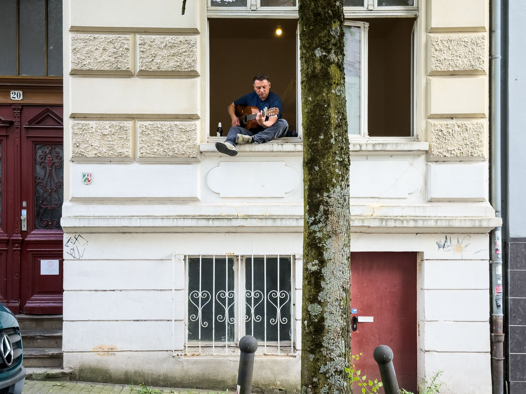 Ein Mann spielt Gitarre in einem Fenster