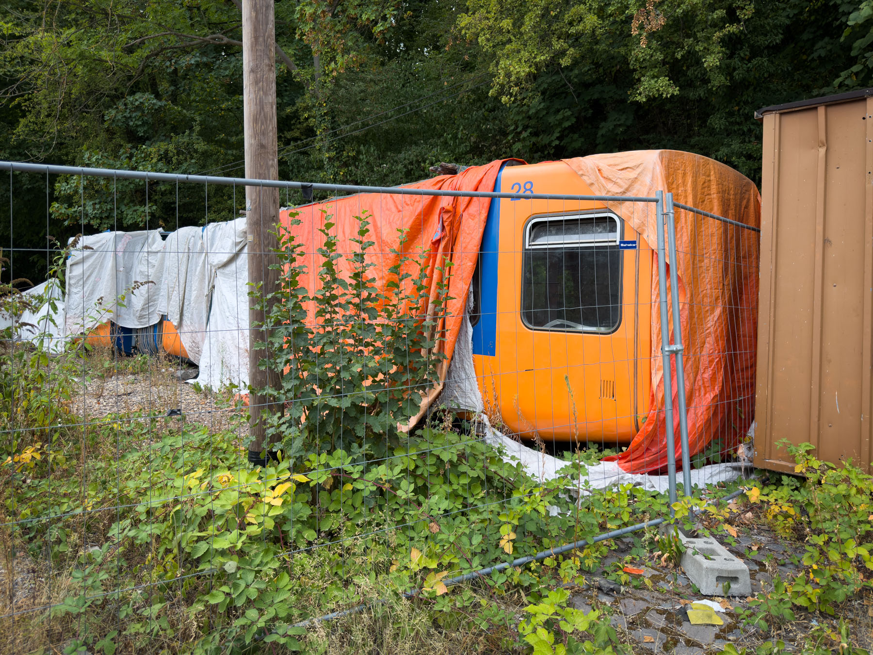 Ein alter Schwebebahnwagen, abgedeckt mit Plastikplanen