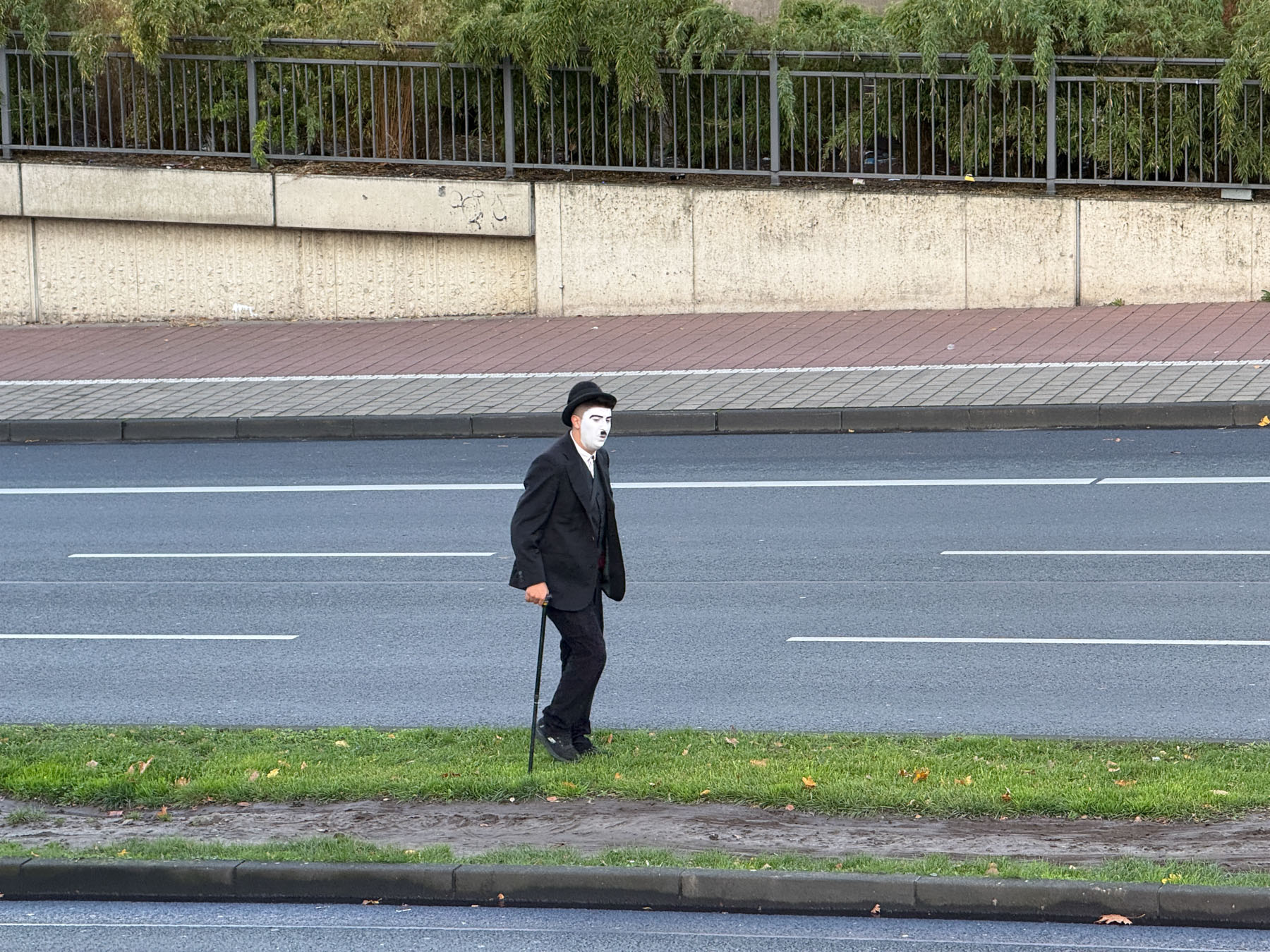Charlie Chaplin läuft über den Grünstreifen der B7