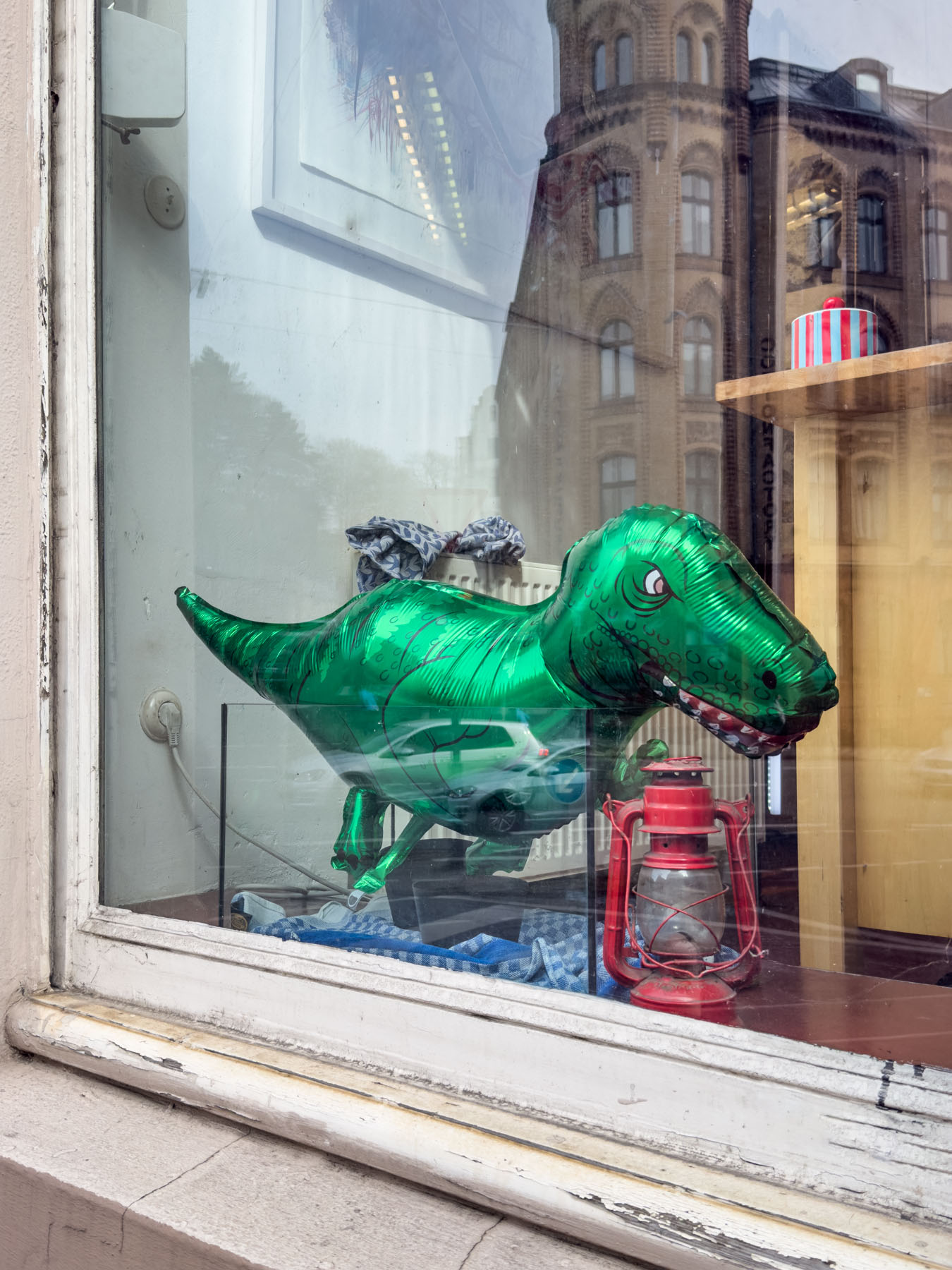 Ein Dinosaurier Luftballon in einem Fenster